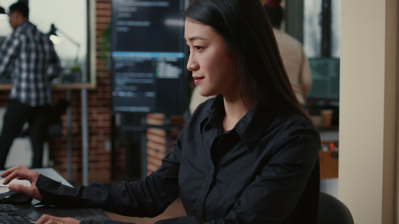 System engineer focused on writing code sitting at desk in software development office