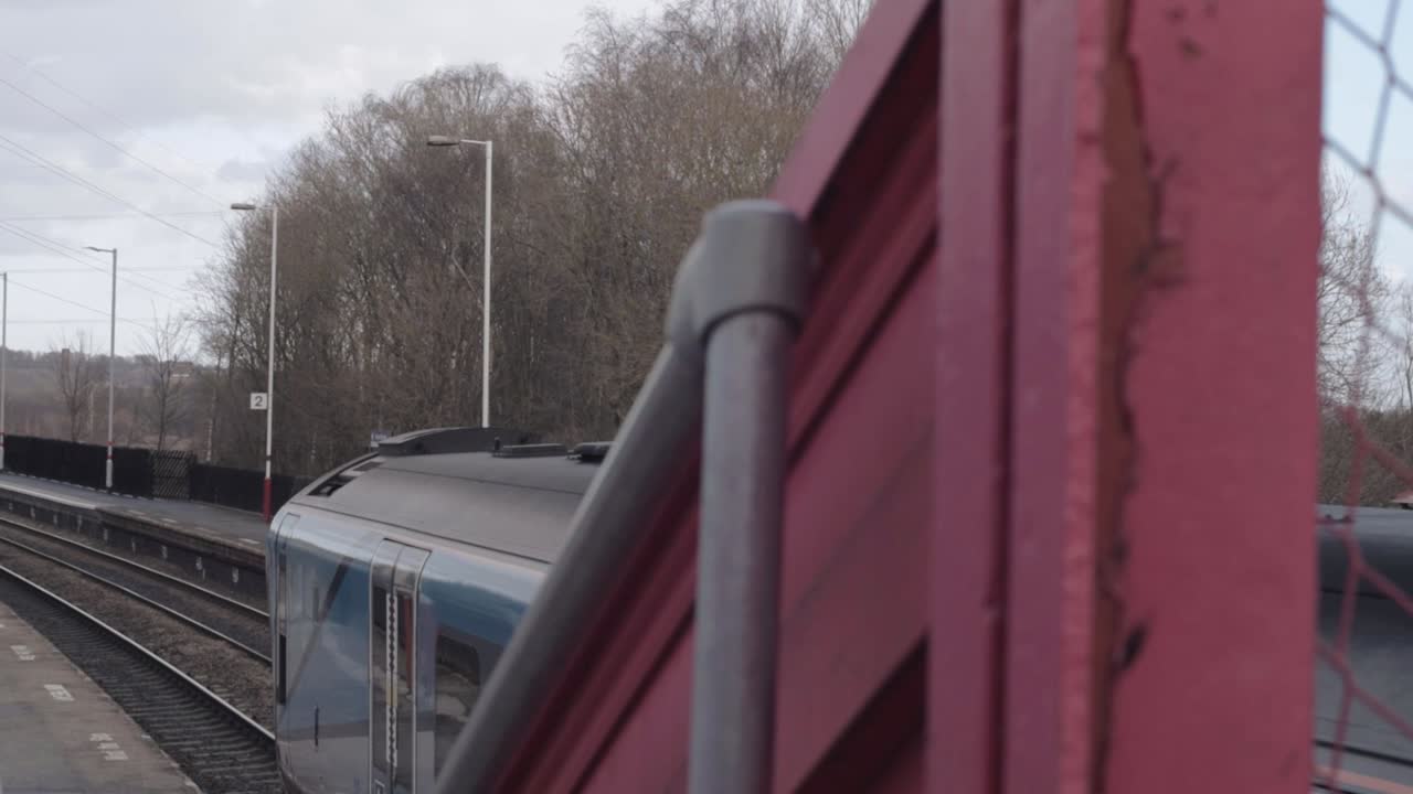 View from bridge of train stopping at railway station