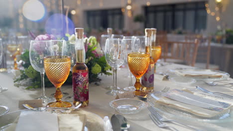 decoration of wedding table with flowers, glasses and gift wine