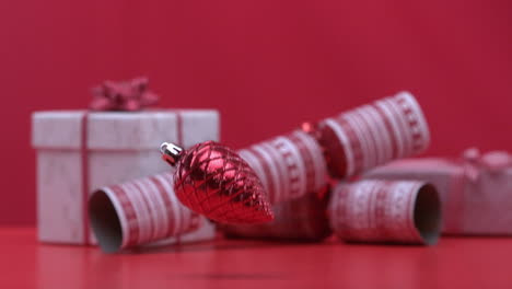 christmas decoration dropping and bouncing beside crackers and presents