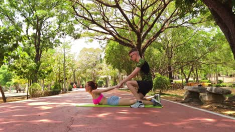 couple practicing yoga outdoors in a park