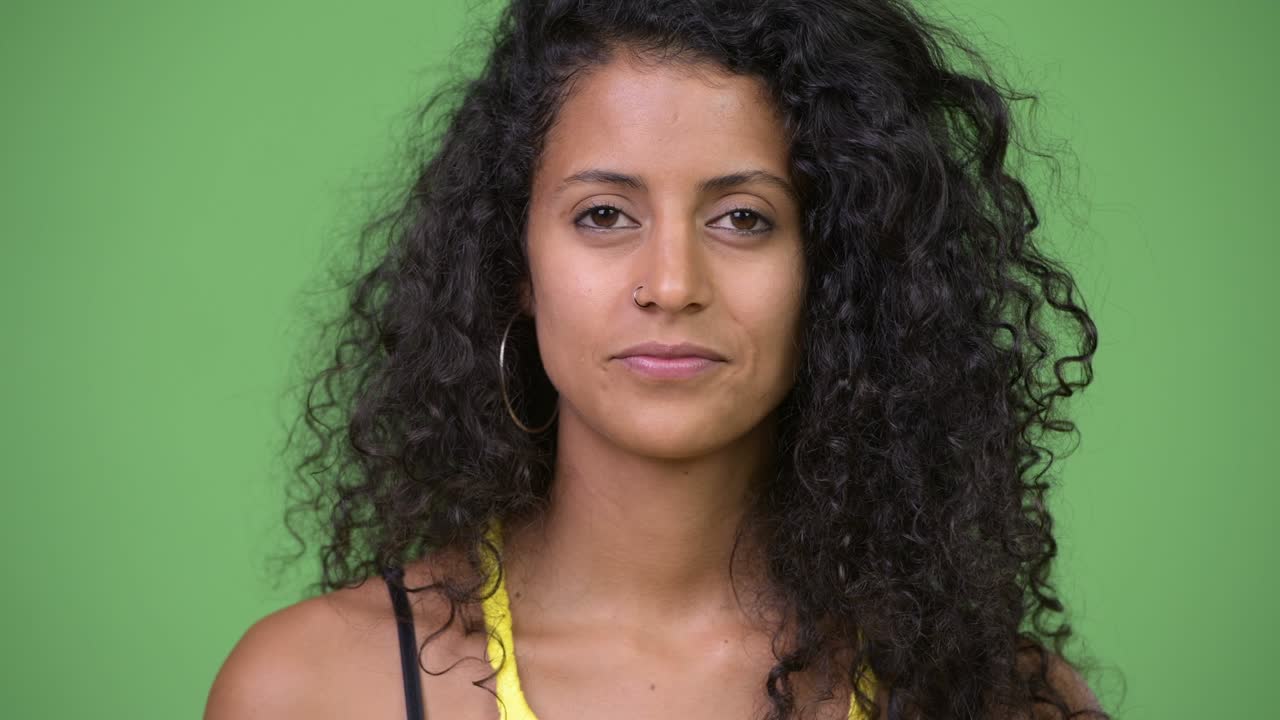 Young beautiful Hispanic woman with finger on lips