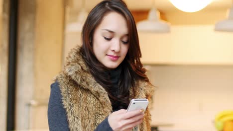 woman using mobile phone in living room