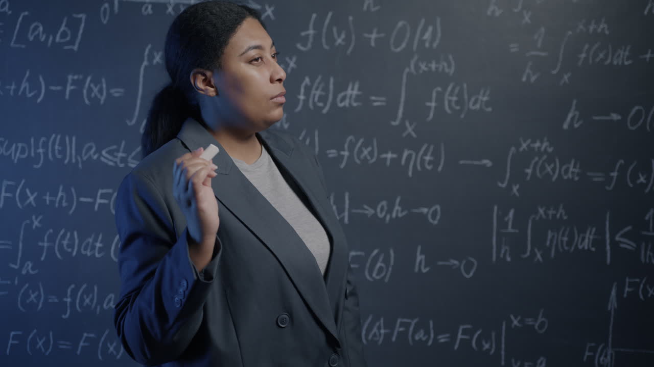 Woman Teacher Explaining Math Concepts on a Chalkboard