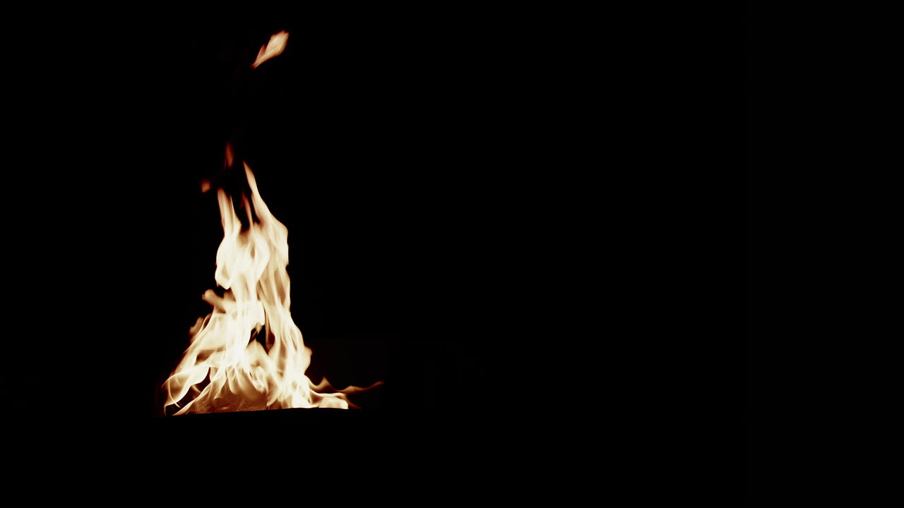 Large group of flames on the left side of frame that grow and die down ...