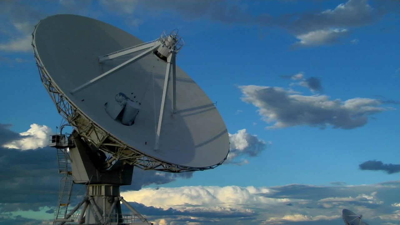 아름다운 하늘을 배경으로 위성 접시가 시간 경과에 따라 움직입니다.