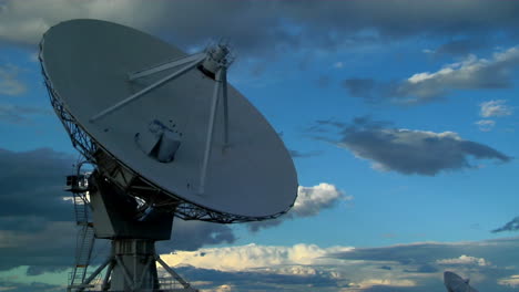 a satellite dish moves in time lapse against a beautiful sky