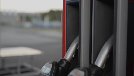 Close-up-of-hand-putting-diesel-pump-nozzle-away-at-a-petrol-station,-in-4K-30fps