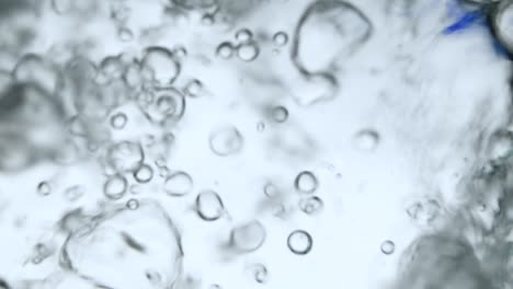 air bubbles in the water while pouring water in glass, photos from the underwater corner. creative abstract background, silver tone style.