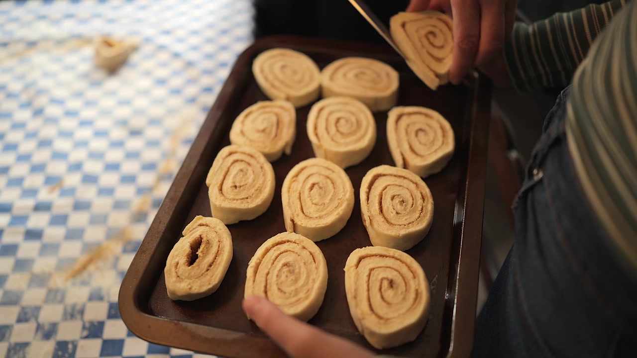 Højt perspektiv: Kanelsnegle lægges på en bageplade før bagning i ovnen.