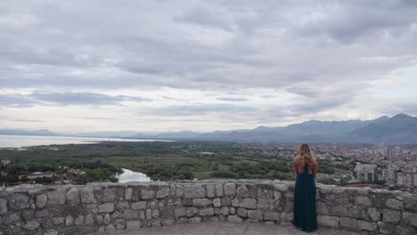 blonde woman in green dress enjoys stunning view from rozafa castle in albania