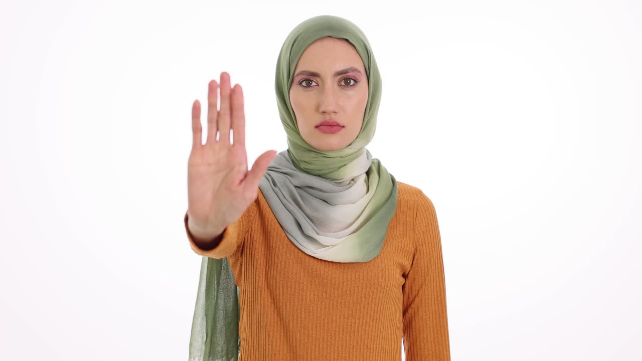 Una donna con hijab che fa un gesto di stop