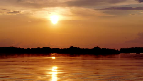 Pequeñas-Ondas-En-El-Lago-Con-Una-Puesta-De-Sol-Dorada-Y-Brillante