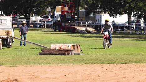 motorcyclist jumps over obstacle in grassy field