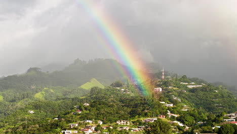 aerial view of rainbow above hills of tahiti island and papeete, french polynesia
