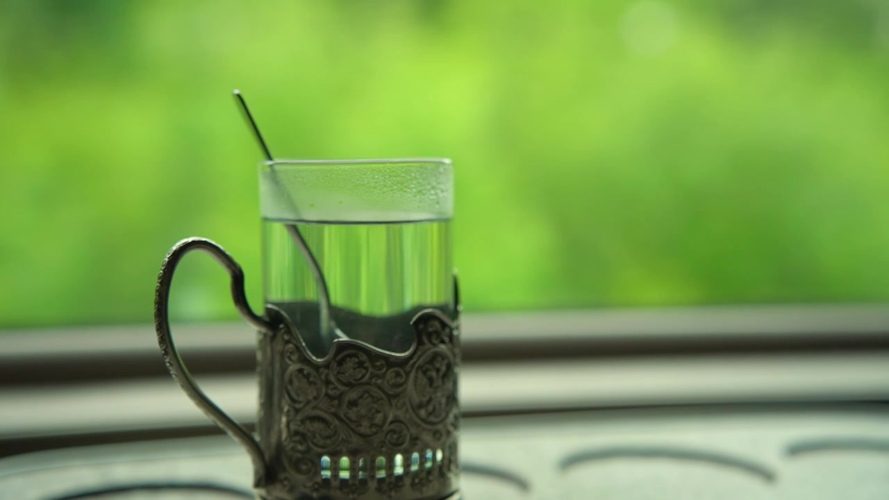 Boisson claire rafraîchissante dans un porte-verre orné près d'une fenêtre