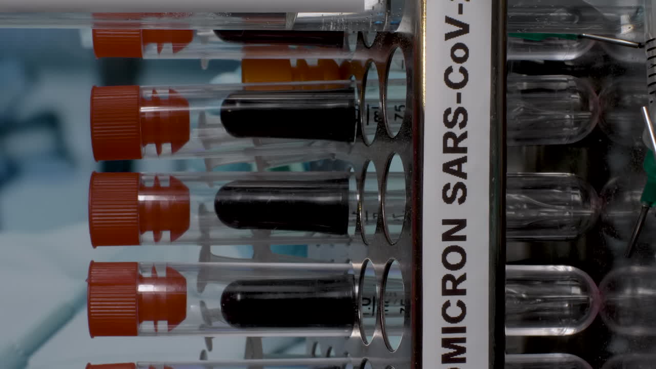 An extreme close up vertical video of glass test tubes containing samples of the new variant of COVID 19 Omicron B.1.1.529 being removed from a laboratory rack