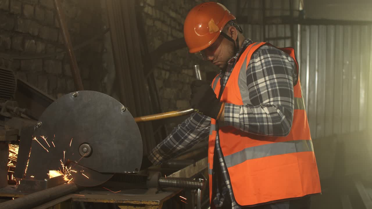 Male worker cutting metal in grungy workshop