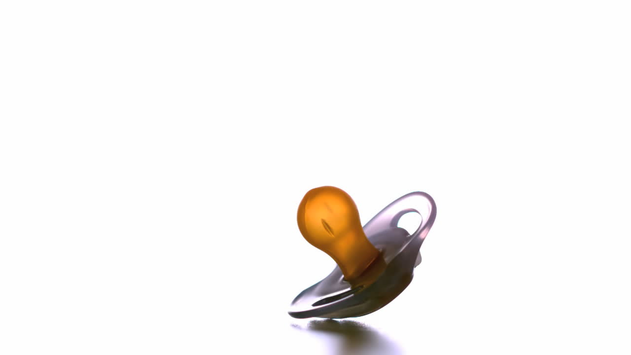 Pacifier falling on white background and bouncing