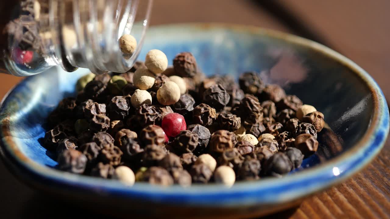 video de primer plano de especias enteras mezcladas de pimienta blanca, pimienta roja y pimienta negra.