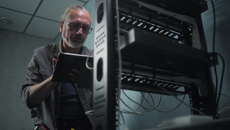 it technician performing maintenance on server racks in a data center