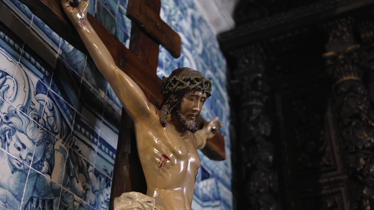 Crucifix of Jesus Christ with crown of thorns, set against traditional blue Portuguese tiles