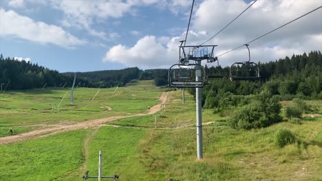 empty ski lift cable way in summer on sunny day with view up the mountain