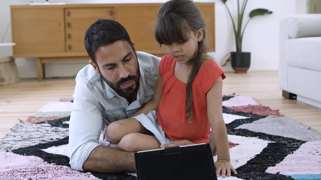 papá y la hija pequeña acostados en el suelo en casa