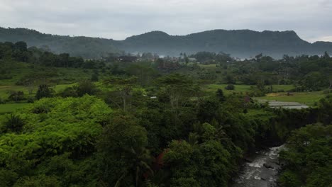 mountains on an overcast morning in the east of bali, surrounded by jungle, aerial