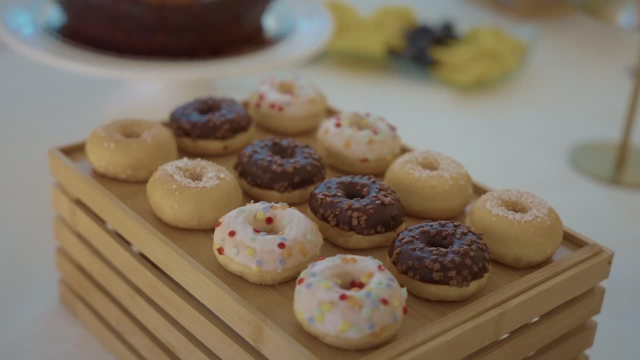 Çikolatalı ve şekerli çeşitli mini donutlar ahşap tepside