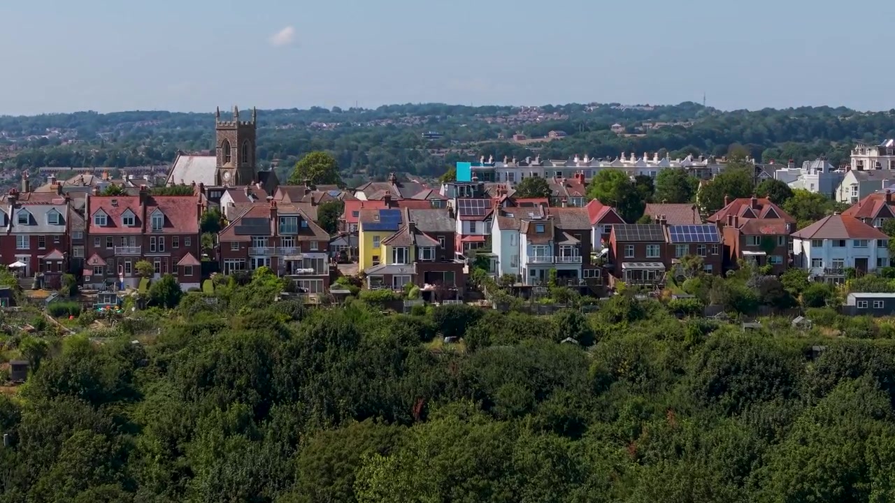Drone si alza sopra la Chiesa di Emmanuel su Priory Road, Hastings, creando un effetto parallasse mentre tetti e colline si dispiegano sotto