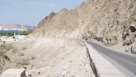 Montañas-Al-Hajar-Y-Puerto-Sultán-Qaboos-En-Muscat,-Omán,-Pan-De-Tiro-Ancho-A-La-Izquierda