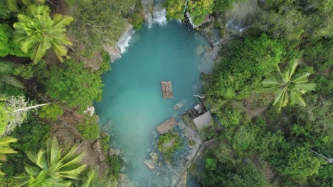 sexy woman in blue bikini lying on bamboo raft in pool of cambugahay fall