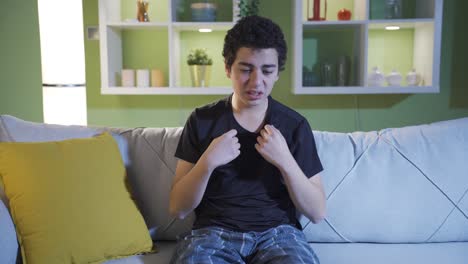 the young man, who is both angry and unhappy because of the incident, sits alone in the living room and blames himself.