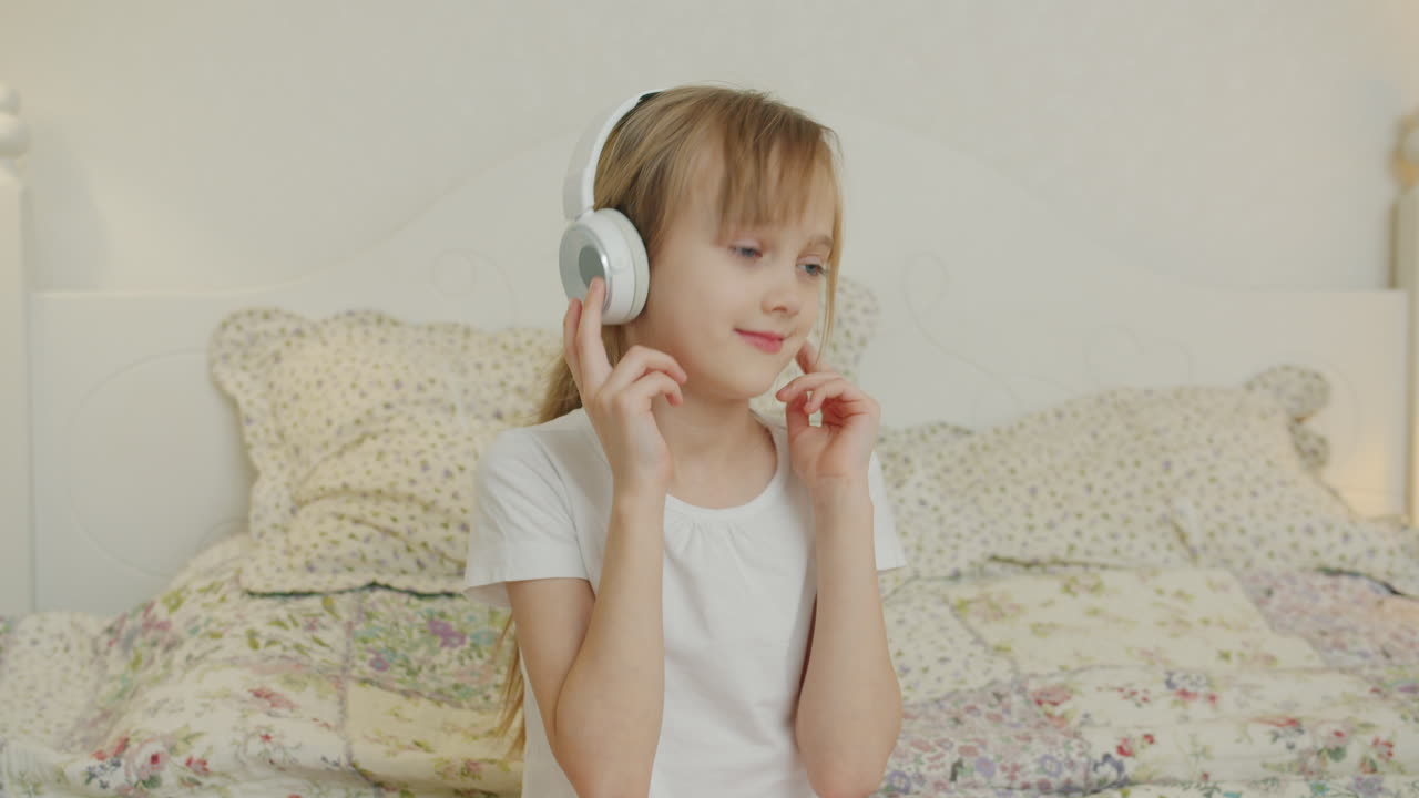 Girl Listening to Music on Headphones in Bedroom