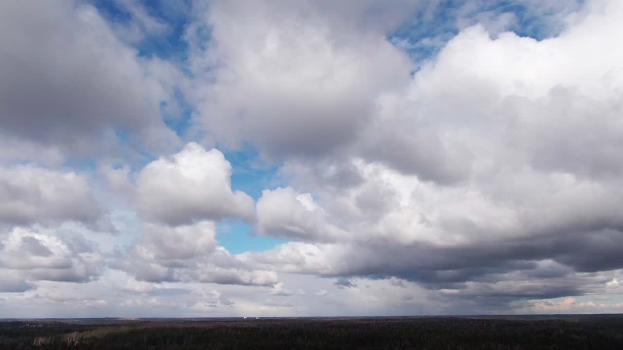 Aerial shot of beautiful soft cloudy blue sky on top of a forest