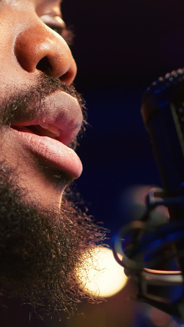 Close-Up of Man Singing into a Studio Microphone