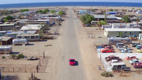 a car drives down bombay beach road towards the sea