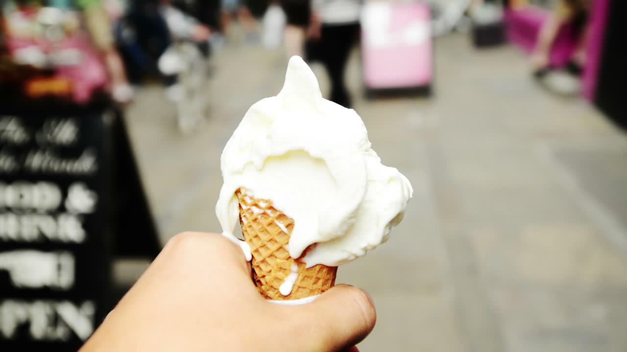 Punto di vista di un uomo con gelato che cammina in città