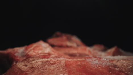 close up dolly macro probe lens studio shot, defrosted fresh uncooked raw red icy meat, culinary raw food thawed product