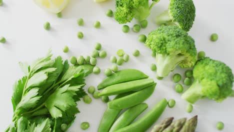 Video-of-close-up-of-fresh-green-vegetables-on-white-background