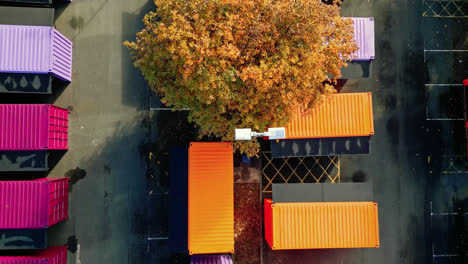 Aerial-footage-of-multicolored-porta-cabins,-market-stalls,-steel-cabins,-storage-units,-shot-from-directly-above-and-moving-slowly-backwards