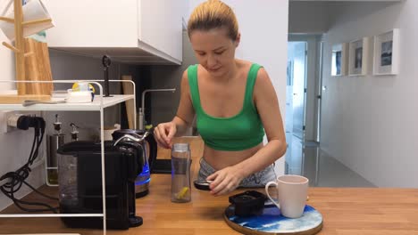mujer haciendo café y té en una cocina moderna