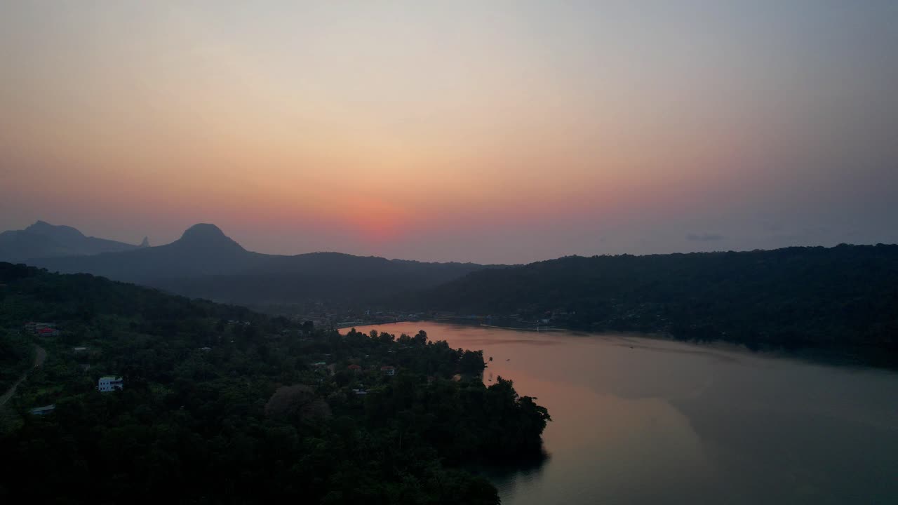 Aerial view of the sun set reflecting in the sea with the city of Santo Antonio in the background, Ilha do Principe (Prince Island) São Tomé,Africa