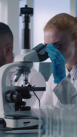 scientists working in a lab using a microscope