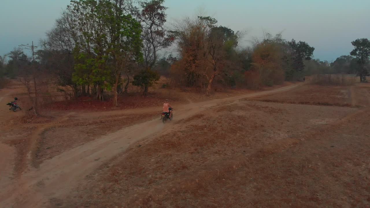 Moto su una strada polverosa a Thakhek al tramonto, Laos
