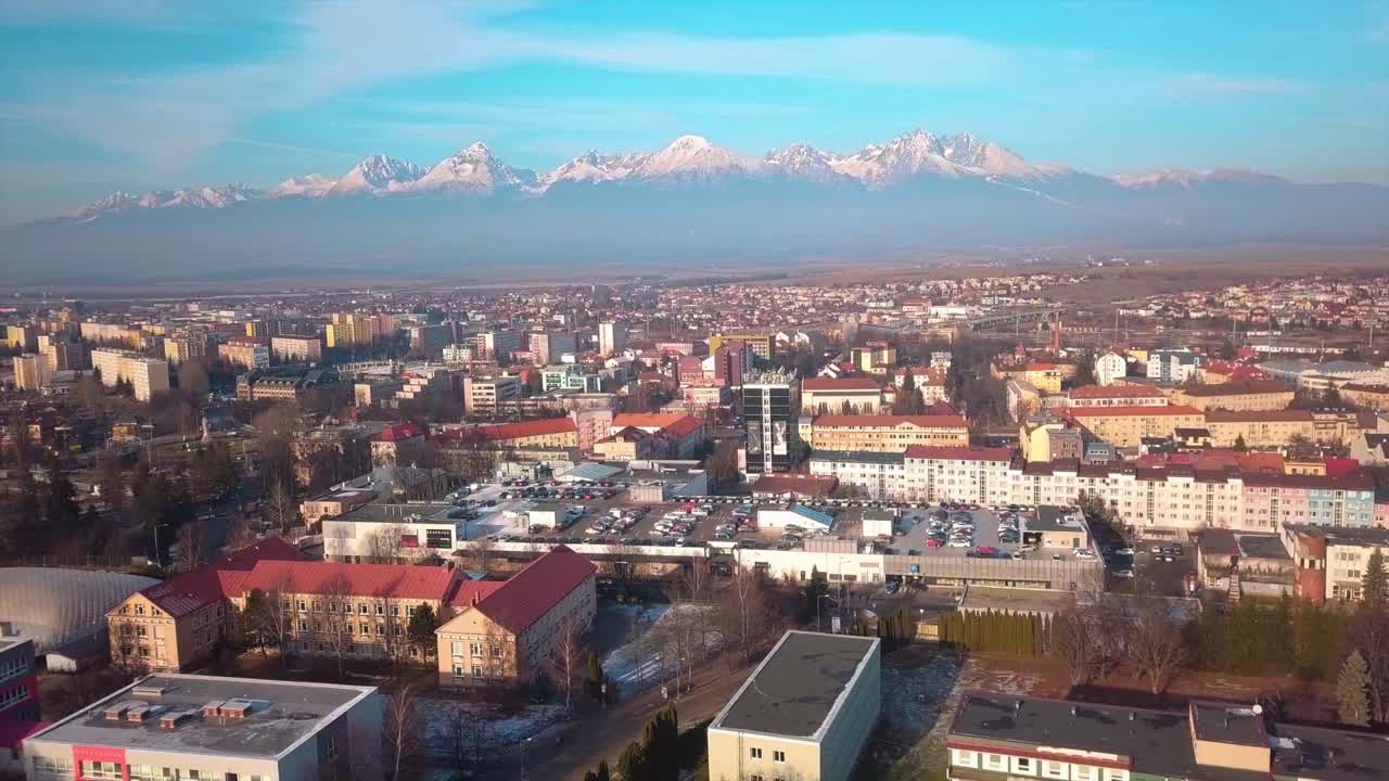 Aerial view of High Tatras mountains behind a slovak town, on a sunny evening