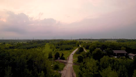 Tracking-Ansicht-Des-Autos-Auf-Sonnenuntergang-Wald-Landstraße-Kreuzung-Bahngleis-Kreuzung