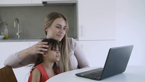 una niña adorable y su mamá viendo contenido