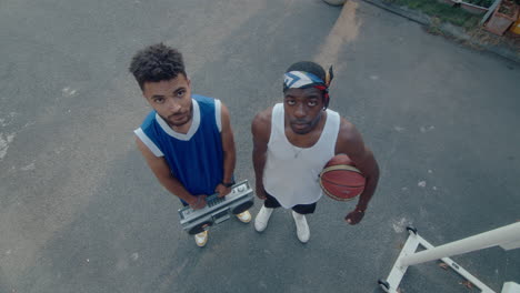 high angle view of two basketball players posing with ghetto blaster and ball